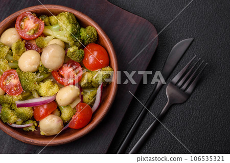 Delicious fresh salad with broccoli, cherry tomatoes, mushrooms, onions, salt, spices and herbs Delicious fresh salad with broccoli, cherry tomatoes, mushrooms, onions, salt, spices and herbs 106535321