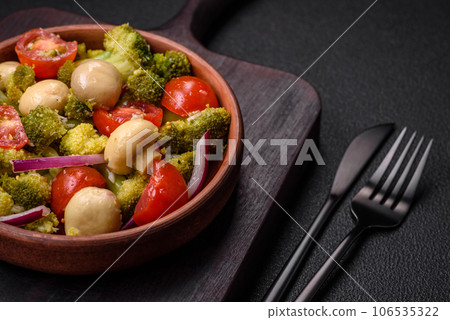 Delicious fresh salad with broccoli, cherry tomatoes, mushrooms, onions, salt, spices and herbs Delicious fresh salad with broccoli, cherry tomatoes, mushrooms, onions, salt, spices and herbs 106535322
