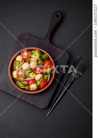 Delicious fresh salad with broccoli, cherry tomatoes, mushrooms, onions, salt, spices and herbs 106535327