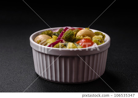 Delicious fresh salad with broccoli, cherry tomatoes, mushrooms, onions, salt, spices and herbs 106535347