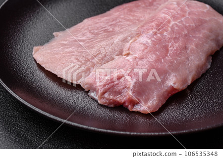 A piece of fresh juicy raw pork with salt, spices and herbs 106535348