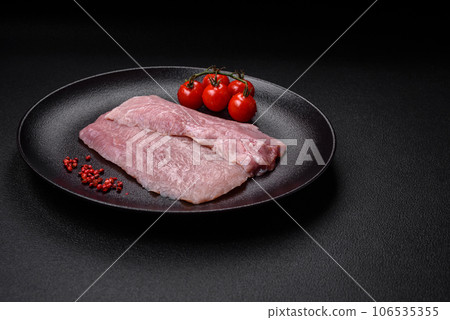 A piece of fresh juicy raw pork with salt, spices and herbs A piece of fresh juicy raw pork with salt, spices and herbs 106535355