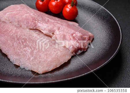 A piece of fresh juicy raw pork with salt, spices and herbs A piece of fresh juicy raw pork with salt, spices and herbs 106535358