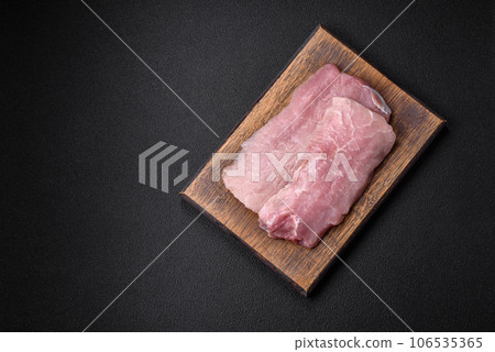 A piece of fresh juicy raw pork with salt, spices and herbs A piece of fresh juicy raw pork with salt, spices and herbs 106535365