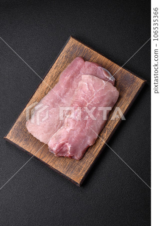 A piece of fresh juicy raw pork with salt, spices and herbs A piece of fresh juicy raw pork with salt, spices and herbs 106535366