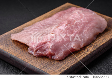 A piece of fresh juicy raw pork with salt, spices and herbs A piece of fresh juicy raw pork with salt, spices and herbs 106535367