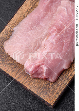 A piece of fresh juicy raw pork with salt, spices and herbs A piece of fresh juicy raw pork with salt, spices and herbs 106535370