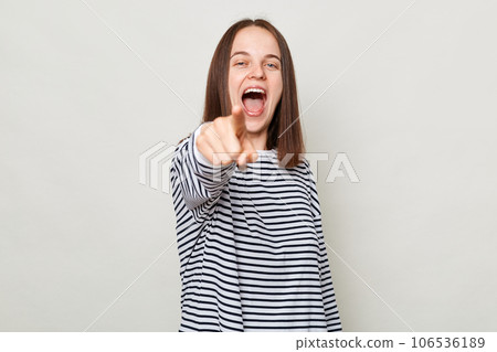 Choosing you. Excited amazed positive brown haired woman wearing striped shirt posing isolated over gray background pointing at camera saying need you Choosing you. Excited amazed positive brown haired woman wearing striped shirt posing isolated over gray background pointing at camera saying need you 106536189