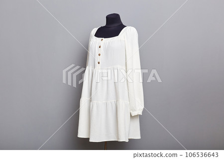 Mannequin with white trendy stylish dress iisolated on gray copy space background in atelier. Mannequin with white trendy stylish dress iisolated on gray copy space background in atelier. 106536643