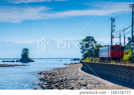 蔚藍的天空和平靜的海浪沿著海岸行駛的當地列車 | 從雨晴海岸到立山連峰的景色 | 富山縣高岡市 106536737