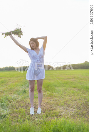 Portrait of a beautiful red-haired girl in the poppies meadow at sunset 106537603