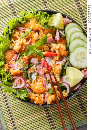 Khao Pad Naem Salad Fried rice ball with fermented pork, vegetables and herbs closeup on the plate. Vertical top view 106537771
