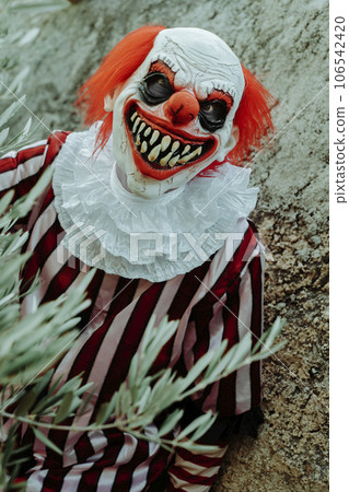 mad evil clown in front of a rustic house mad evil clown in front of a rustic house 106542420