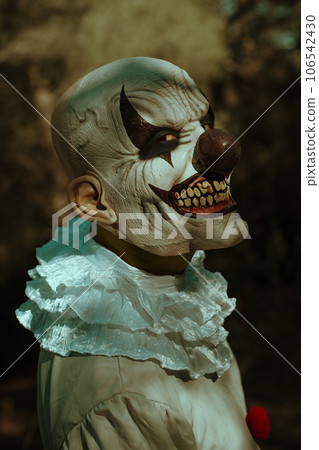bald evil clown turns around in the woods 106542430