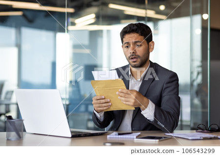 Upset and disappointed with the results of the achievement, young businessman received a mail message, hispanic man desperately reads the news, man works inside the office with a laptop. 106543299