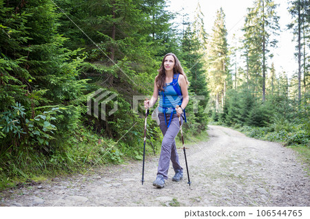 Young woman hiking through the forest in mountains Young woman hiking through the forest in mountains 106544765