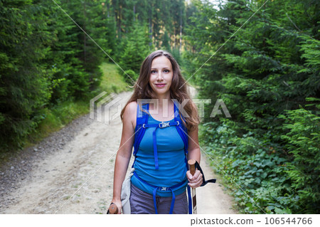 Young woman hiking through the forest in mountains 106544766