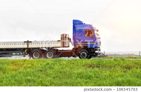 A truck with a semi-trailer transports cargo in the summer on a motorway in rainy weather. Copy space for text 106545783