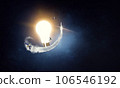 Light bulb glowing in darkness 106546192