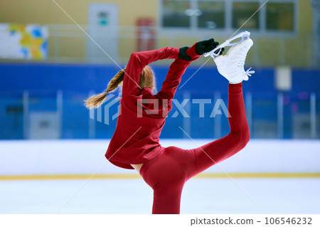 Talented, flexible girl in motion, figure skating athlete in red sportswear training on ice rink arena. Championship preparation 106546232