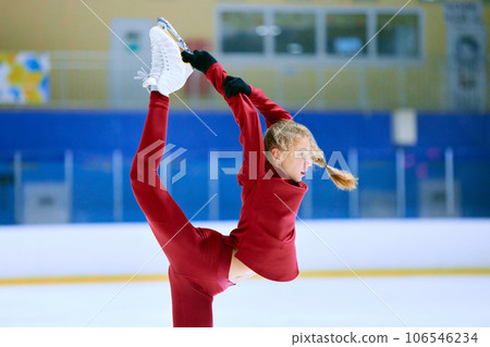 Talented, flexible girl in motion, figure skating athlete in red sportswear training on ice rink arena. Championship preparation Talented, flexible girl in motion, figure skating athlete in red sportswear training on ice rink arena. Championship preparation 106546234