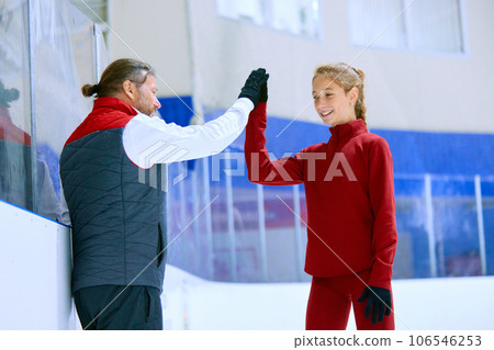 Success. Figure skating trainer, coach cheering his student, girl, giving high five. Ice rink arena background Success. Figure skating trainer, coach cheering his student, girl, giving high five. Ice rink arena background 106546253