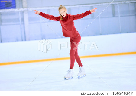 Talented girl, teenager in red sportswear, figure skating athlete in motion, training on ice rink arena 106546347