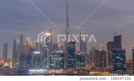 Aerial view to Dubai Business Bay and Downtown with the various skyscrapers and towers day to night timelapse 106547136