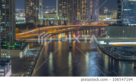 Walking promenade along water canal in Business Bay district of Dubai aerial night timelapse. 106547194