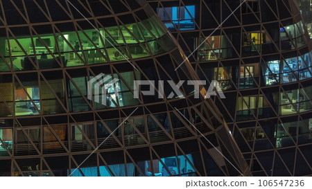 Frontal view of night facade of apartment building with a lot of windows with light timelapse. Frontal view of night facade of apartment building with a lot of windows with light timelapse. 106547236