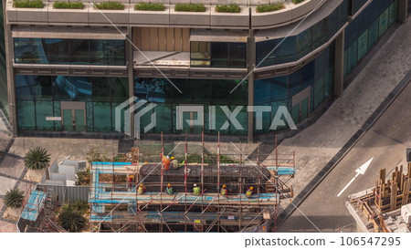 Many workers on the construction site making reinforcement metal framework for concrete pouring aerial timelapse 106547295