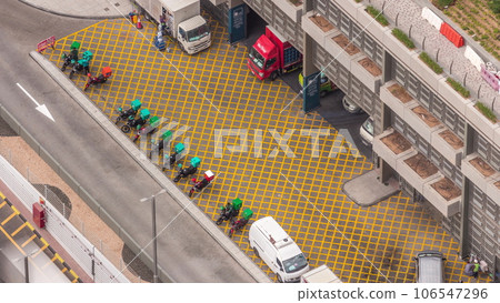 Row of food delivery service motor bikes in Dubai street aerial timelapse. 106547296