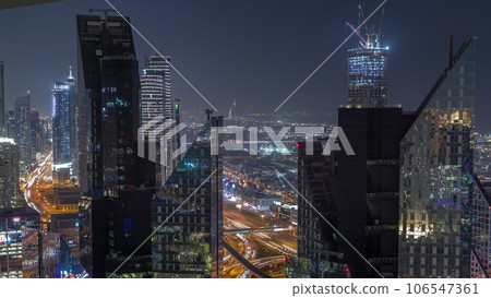 Aerial view from above to a busy road junction in Dubai night timelapse. 106547361