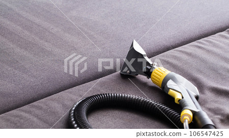 Modern professional washing vacuum cleaner for upholstered furniture on a black background. The concept of dry cleaners at home. Copy space for text 106547425