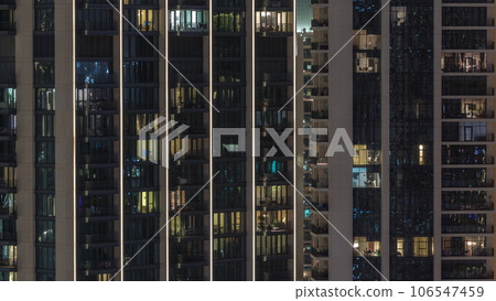 Tall blocks of flats with glowing windows located in residential district of city aerial timelapse. 106547459
