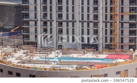 Swimming pool construction site with on the rooftop of parking with many workers aerial timelapse. 106547528