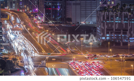 Top aerial view of busy road intersection and traffic junctions in Dubai city night timelapse. Top aerial view of busy road intersection and traffic junctions in Dubai city night timelapse. 106547591