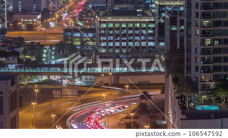 Top aerial view of busy road intersection and traffic junctions in Dubai city night timelapse. Top aerial view of busy road intersection and traffic junctions in Dubai city night timelapse. 106547592