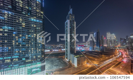 Many towers and skyscrapers with traffic on streets in Dubai Downtown and financial district night timelapse. 106547594