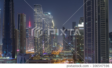 Many towers and skyscrapers with traffic on streets in Dubai Downtown and financial district night timelapse. Many towers and skyscrapers with traffic on streets in Dubai Downtown and financial district night timelapse. 106547596