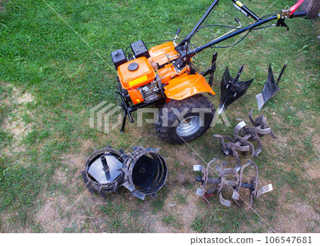 Agricultural walk-behind tractor with a set of attachments, hiller, milling cutters and lugs. Two-wheel tractor, industry Agricultural walk-behind tractor with a set of attachments, hiller, milling cutters and lugs. Two-wheel tractor, industry 106547681
