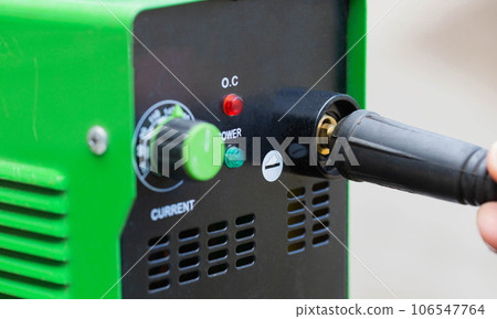 Adjusting the current strength on a modern welding machine. Welding arc. Close-up Adjusting the current strength on a modern welding machine. Welding arc. Close-up 106547764