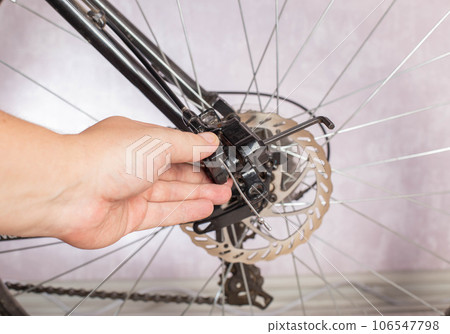 Unscrewing the brake shoe of the bicycle brake caliper with a hexagon. Replacement of brake pads, close-up 106547798