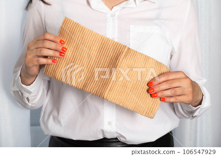 The girl holds in her hands an orthopedic medical knee brace for fixing the knee joint, warming and micromassage. The girl holds in her hands an orthopedic medical knee brace for fixing the knee joint, warming and micromassage. 106547929