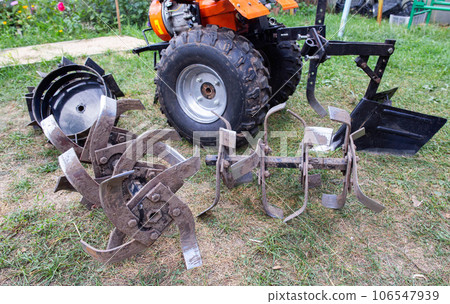 Agricultural walk-behind tractor with a set of attachments, hiller, milling cutters and lugs. Two-wheel tractor, industry 106547939