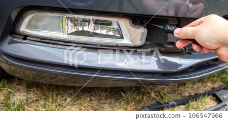 Unscrewing and disassembling the fog lamp in a car to replace the light bulb with a new one, close-up Unscrewing and disassembling the fog lamp in a car to replace the light bulb with a new one, close-up 106547966