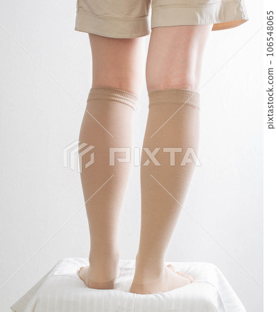 Female legs in compression stockings for varicose veins on the legs. White background. Circulation in the legs. thrombosis in the veins, lymphedema. Chronic venous insufficiency 106548065