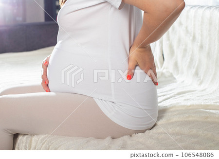 Kidney pain in a pregnant girl, cystitis and pyelonephritis. Exacerbation of chronic diseases in pregnant women, close-up Kidney pain in a pregnant girl, cystitis and pyelonephritis. Exacerbation of chronic diseases in pregnant women, close-up 106548086