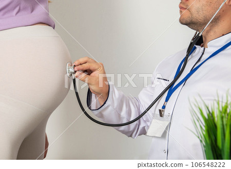 Doctor obstetrician gynecologist using a stethoscope for pregnant women listens to the mobility and heartbeat of the fetus in the womb, unrecognizable Doctor obstetrician gynecologist using a stethoscope for pregnant women listens to the mobility and heartbeat of the fetus in the womb, unrecognizable 106548222