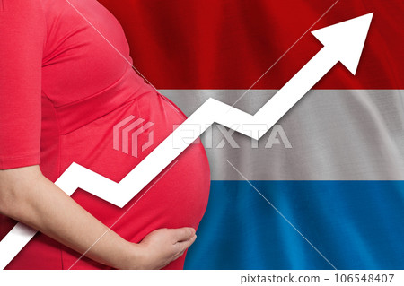Photo of pregnant woman on flag of Grand Duchy of Luxembourg background. Birth rate up 106548407